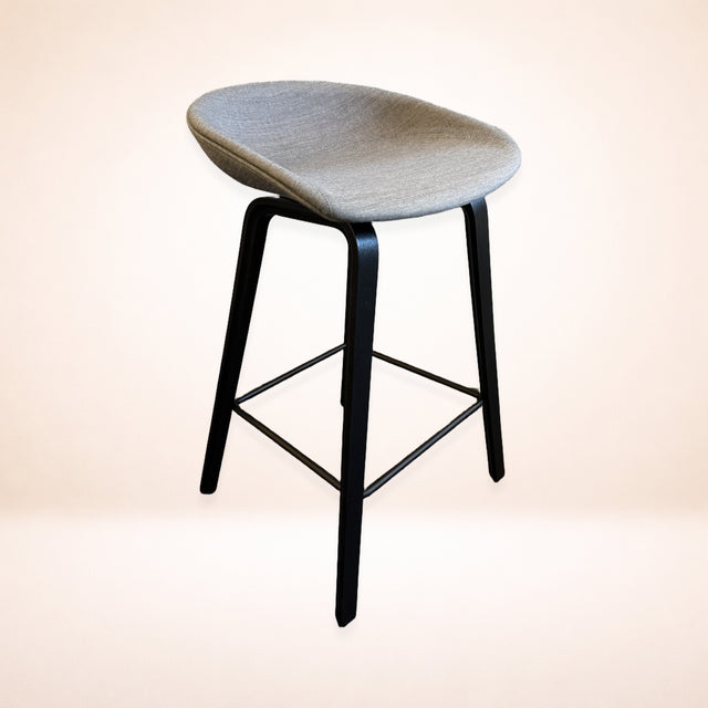 Barstol HAY About a Stool i grått tyg med svarta ben, snett framifrån